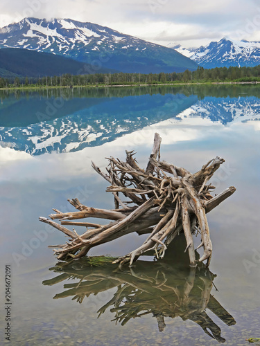 Alaska landscape on the Kenai Pennisula - Early morning mist parts to expose the mountain range and reflections in the lake