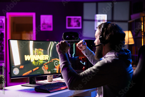 Cuadro en lienzo Esports player playing videogames in front of subscribers during livestream, celebrating after winning online match