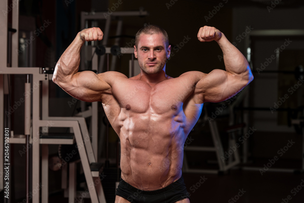 Fototapeta premium Muscular Man Is Hitting Rear Double Bicep Pose