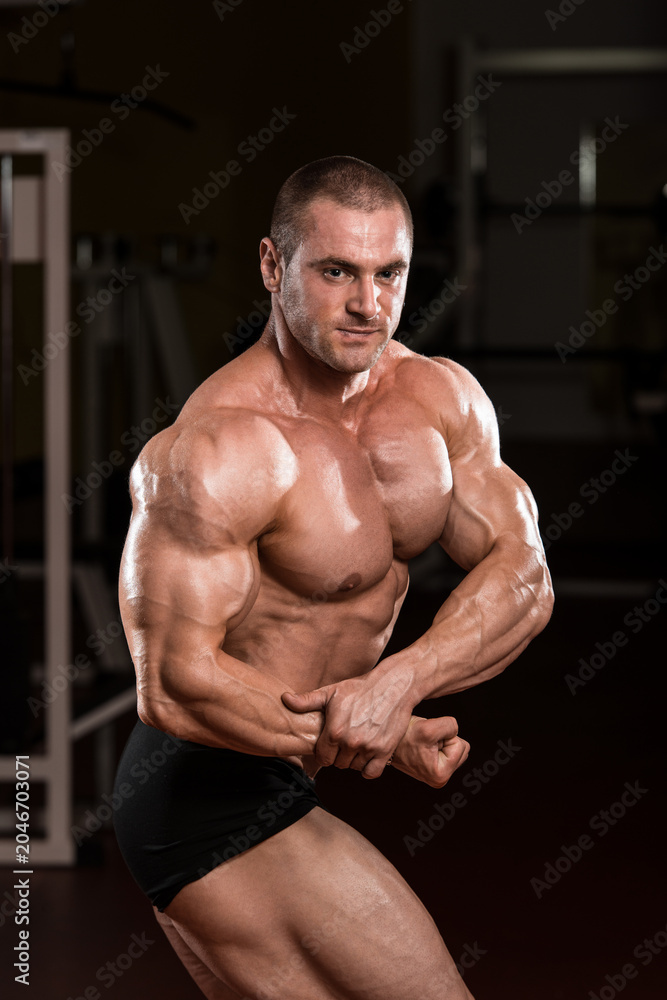 Fototapeta premium Young Bodybuilder Flexing Muscles