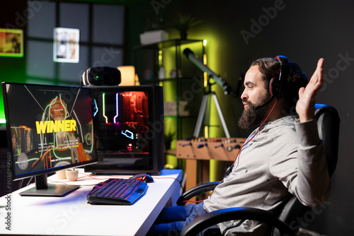 Canvas Print Cheerful gamer in apartment feeling relieved after finally receiving winner screen for killing all enemies
