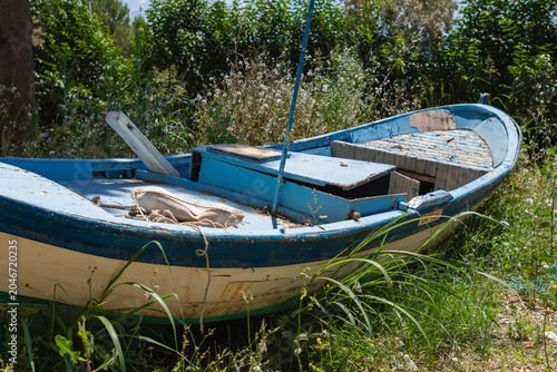 Foto Small vintage rowboat stranded on a field, rustic maritime scenery on a sunny da