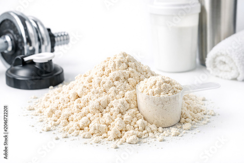 Organic protein powder and gym accessories on white table