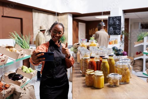 Cuadro en lienzo A young black woman with an apron making a vlog, with a thumbs up assures online clients of sustainable products