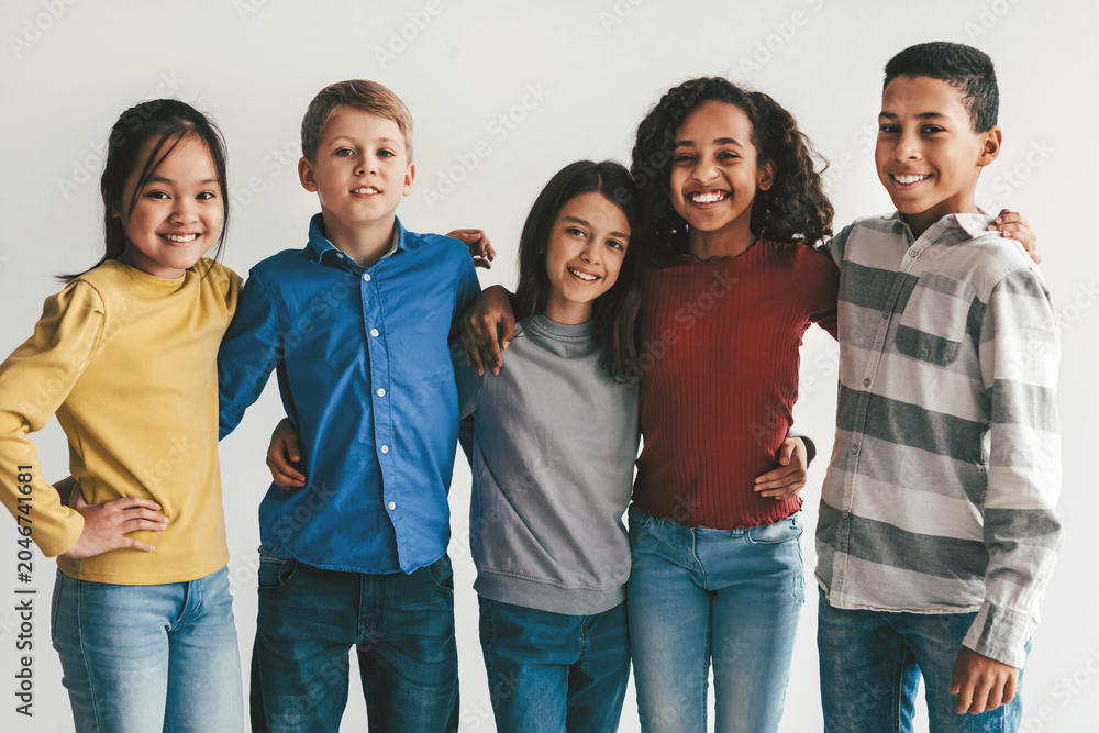 Obraz premium Smiling Group Of Multiracial Children, Three Females And Two Males, Posing Together With Joy At Studio Setting, Celebrating Friendship And Togetherness, Showcasing Diversity And Happiness