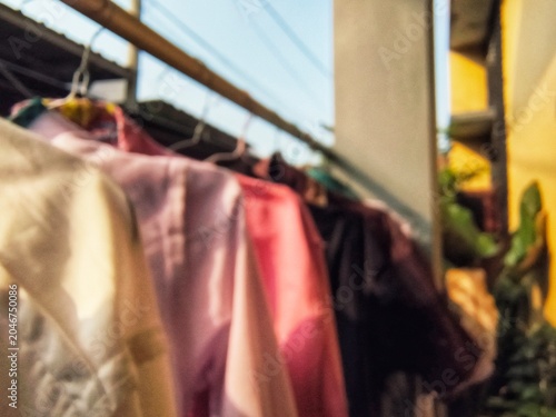 Foto Blurred abstract background of colourful clothes hanging on a drying rack outdoo