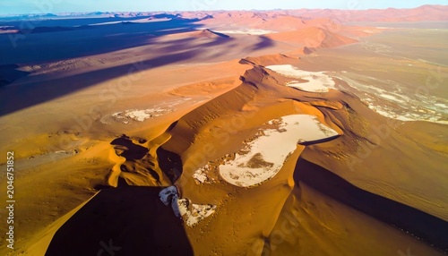 Expansive Namibian Desert Dunes Seen From Above With Stark Contrasts of Sand and Salt Pan Formations