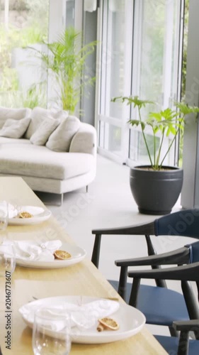 Vertical video: Pulling back from close-up, cam showing table set in dining area with rolls, candle