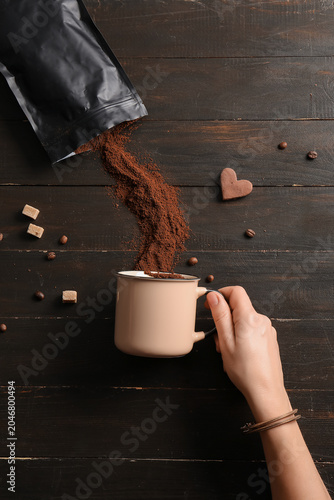 Female hand with cup and ba...
