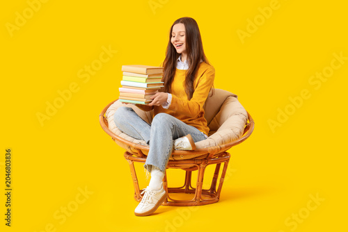 Young woman with stack of b...