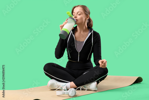 Sporty young woman drinking...