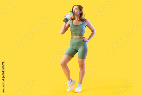 Sporty young woman drinking...