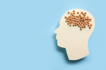 Paper human head with chickpeas on blue background. World Mental Health Day
