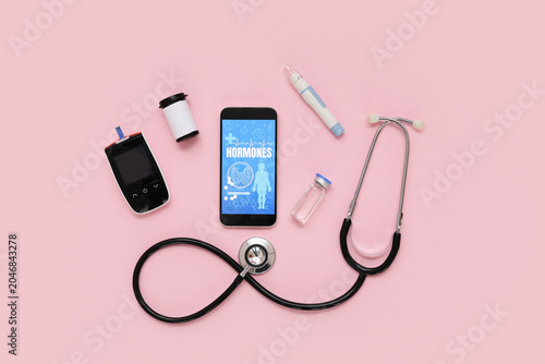 Tableau sur toile Mobile phone with glucometer, lancet pen and stethoscope on pink background