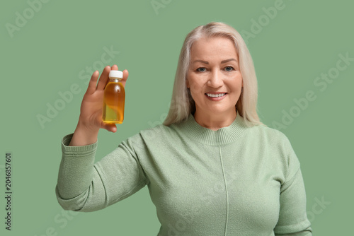 Mature woman with bottle of...