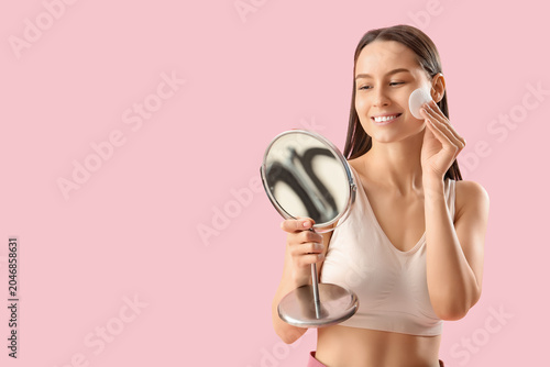 Young woman with cotton pad...