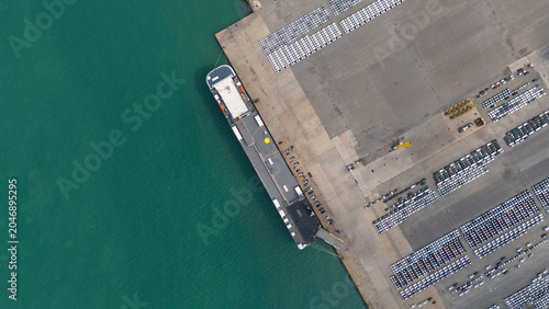 Top view of port, electric car shipping yard and intercontinental shipping industry.	