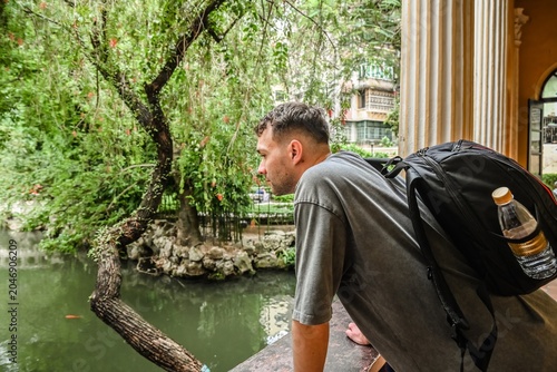 Fotografia 30 years old Russian man tourist on solo travel looking at fish pond inside Lou