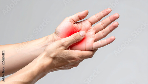 Medical concept showing hand pain, one hand supporting the other with highlighted red inflammation zones.
