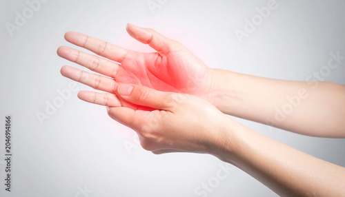 Close-up of a hand pressing a painful palm, with red inflamed areas highlighting discomfort and joint pain.