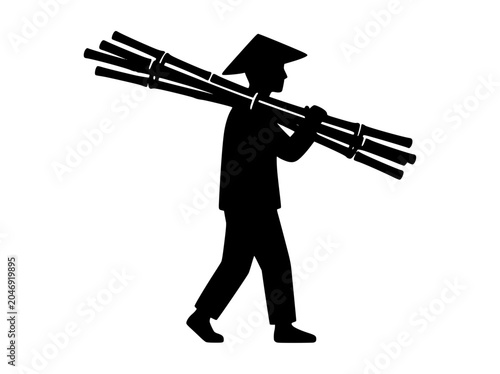 Silhouette of an Asian farmer carrying a bundle of bamboo sticks