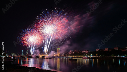 Independence Day Fireworks Over River With City Lights