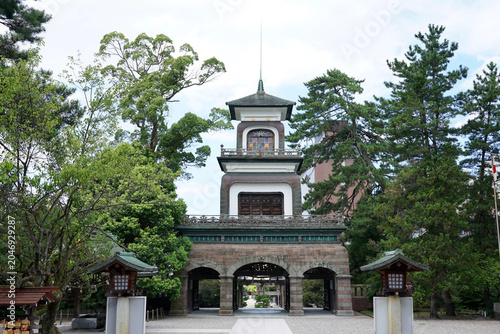 Historic Japanese Temple Tower Amid Garden Trees With Traditional Architecture and Stone Arches