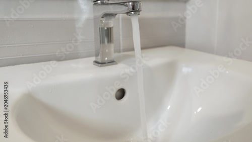 Foto The continuous flow of water from an open tap illustrates wasteful habits, stressing the value of adopting mindful water-saving measures in everyday life to support sustainability