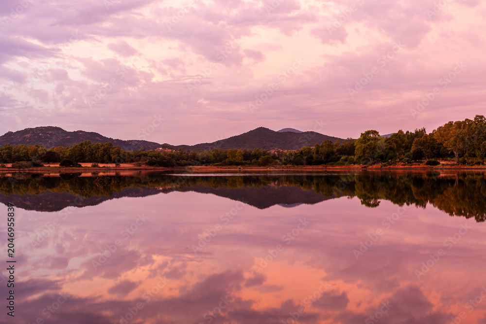 Obraz premium S'Ena e Sa Chitta coastline with calm sea at sunset. Reflections of sky on water. Sardinia, Italy, Mediterranean landscape.