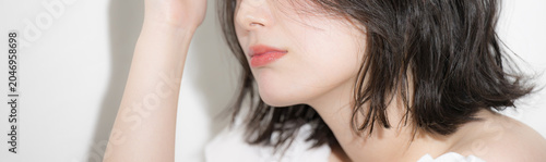 アンニュイな表情が魅力的な透明感のある素肌の若い女性のビューティーポートレート　ヘアケアや美容など顔無しの口元のクローズアップバナー