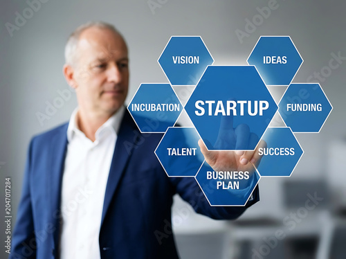 Businessman touches blue hexagon graphic with startup related words touching