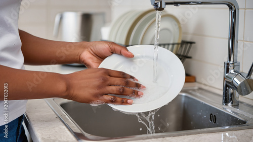 Bild auf Leinwand Washing dishes by hand in a kitchen sink