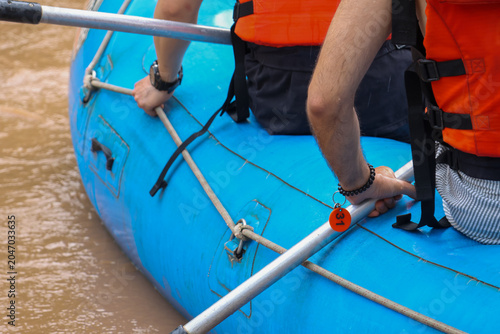 Cuadro en lienzo Thrilled people enjoy active outdoor sport adventure paddling blue raft in brown