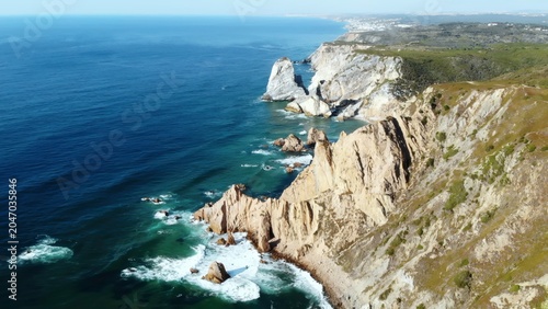 Bild auf Leinwand Challenging Coastal Landscape Of Jagged Limestone Cliffs Struck By Powerful Surf And Soaring Seabirds