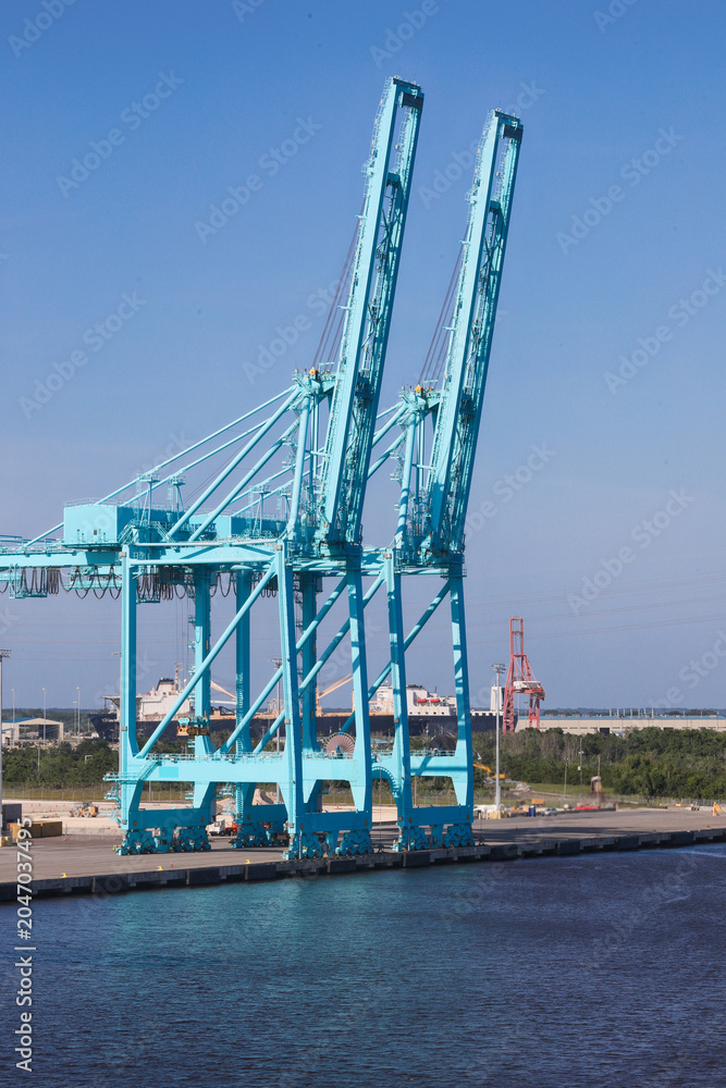 Obraz premium view usa cargo ship terminal, Unloading crane of cargo ship terminal, Aerial view industrial port with containers and container ship.