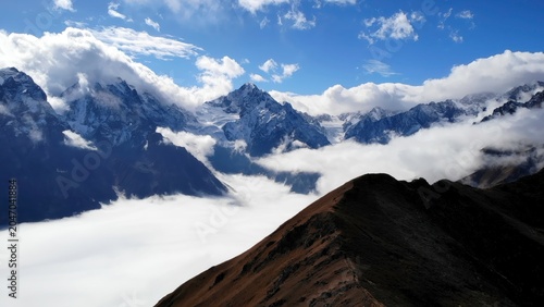 Fotografie Serene Alpine Landscape Displaying Snowcapped Summits And Extensive Sky Adorned With Clouds