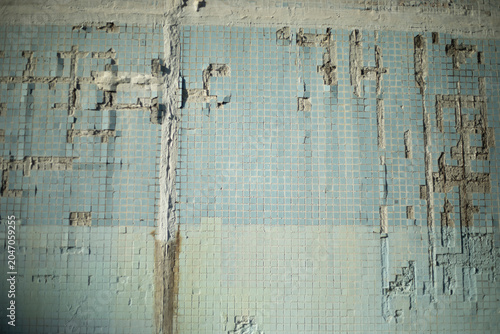 The tile wall is old. Tiles were falling off the wall. The damaged surface of the house.