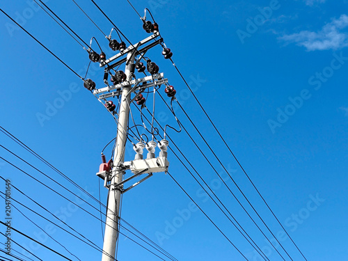 high voltage power lines against blue sky