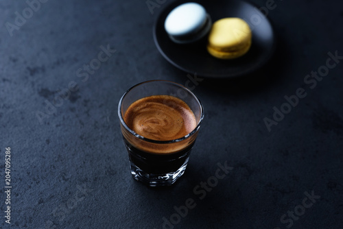 Coffee in glass cup on a dark stone background. Soft focus. Close up. Copy space.