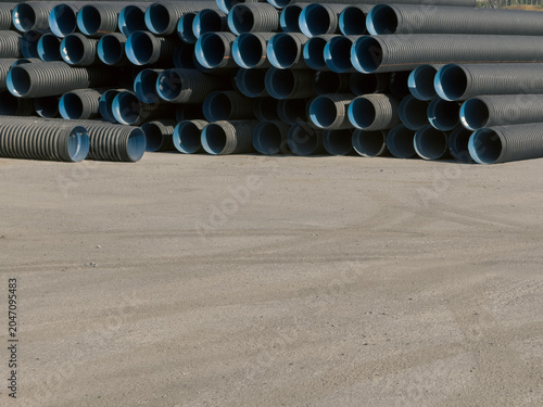 View of stacked black corrugated plastic pipes with blue interiors on a construction site Sariyer, Istanbul, Turkiye.