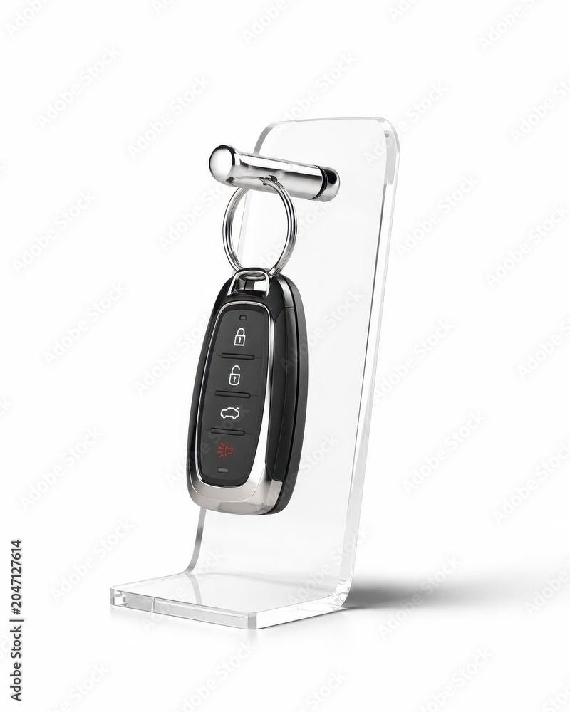 Fototapeta premium Generic car key fob hanging from a polished chrome hook on a transparent acrylic display stand luxury new car handover concept isolated on white background clean studio lighting