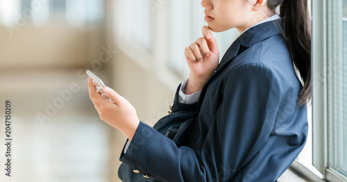 Photos Smiling elementary, middle, and high school girls using smartphones in the schoo