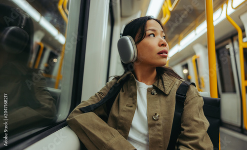 Woman listening on train with headphones during commute