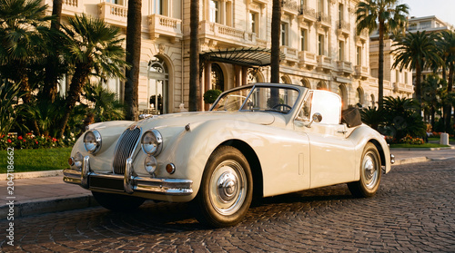 Vintage convertible outside a grand Riviera hotel at golden hour