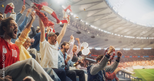 Diverse  Men and Women in Stadium Seating Explode Into Joyous, Cheers During a Soccer Championship Match, Raising Scarves and a Tambourine as Confetti Falls After a Dramatic Score.