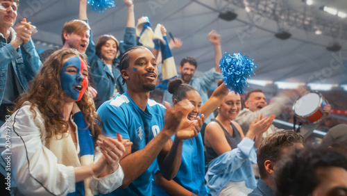 Fotografija Excited Diverse Men and Women Fans With Face Paint Clap Hands and Wave Blue Pom Poms at Soccer Football Championship in Stadium, Happy Smiling Supporters Cheer Goal During World Cup Tournament Match