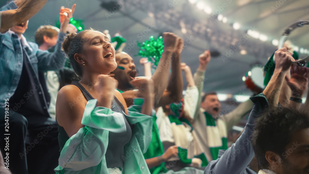 Obraz premium Portrait of a Happy White Female Supporter Raising Fists and Cheering for Her Team at a Soccer Football Championship Match, Excited Diverse Fans in a Stadium Celebrating a Score During a Game.