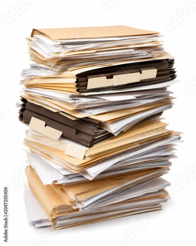 Overflowing archive stack with accordion paper files and loose sheets cascading in a controlled arrangement blank filing tabs realistic office backlog concept