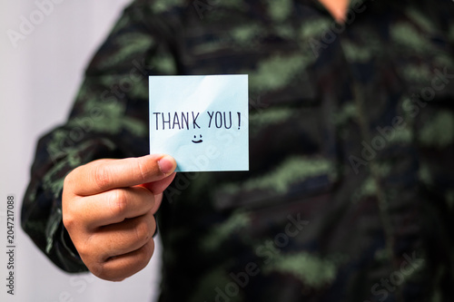 Soldier on a military base expressing gratitude and appreciation with a thank you note