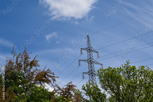 High voltage power lines and tower, symbolizing electricity costs, energy crisis, and cost of living.